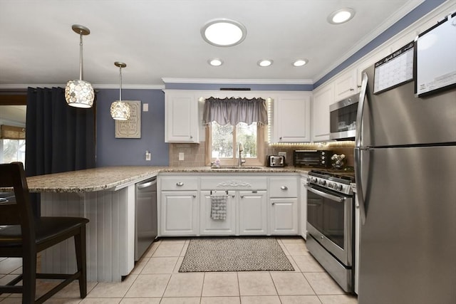 kitchen featuring a peninsula, a sink, white cabinetry, ornamental molding, and appliances with stainless steel finishes