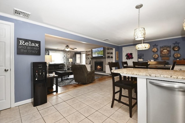 kitchen featuring a brick fireplace, visible vents, stainless steel dishwasher, and light tile patterned floors