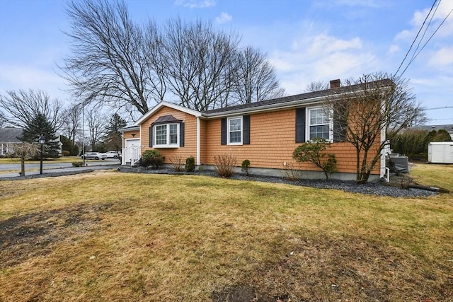 view of front of property with an attached garage, a chimney, and a front yard