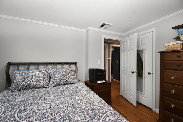 bedroom featuring ornamental molding, wood finished floors, and visible vents