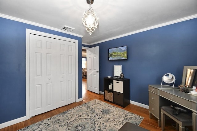 office space with baseboards, visible vents, wood finished floors, an inviting chandelier, and crown molding