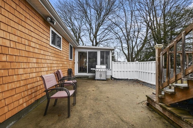 view of patio / terrace with a sunroom, stairs, fence, and area for grilling