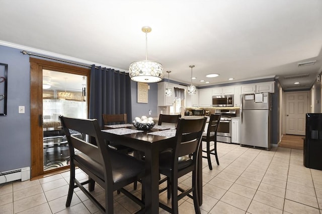 dining area with a baseboard heating unit, plenty of natural light, ornamental molding, and light tile patterned floors