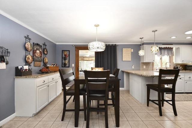 dining area with light tile patterned floors, baseboards, and ornamental molding