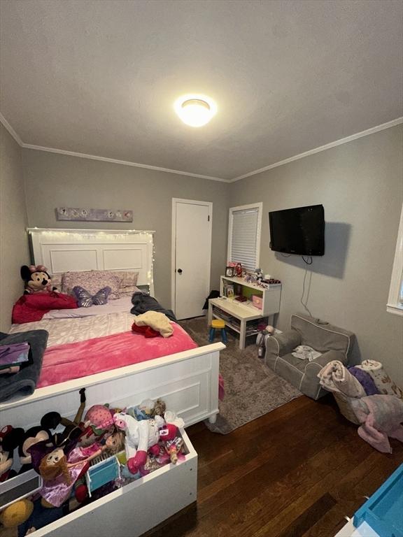 bedroom featuring dark hardwood / wood-style flooring and ornamental molding