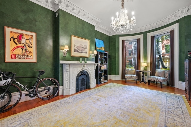 living area with hardwood / wood-style floors, crown molding, and a chandelier