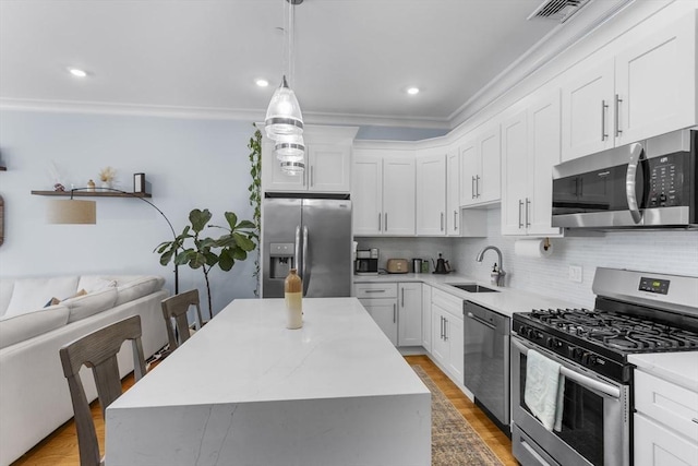 kitchen featuring appliances with stainless steel finishes, white cabinets, and a kitchen island