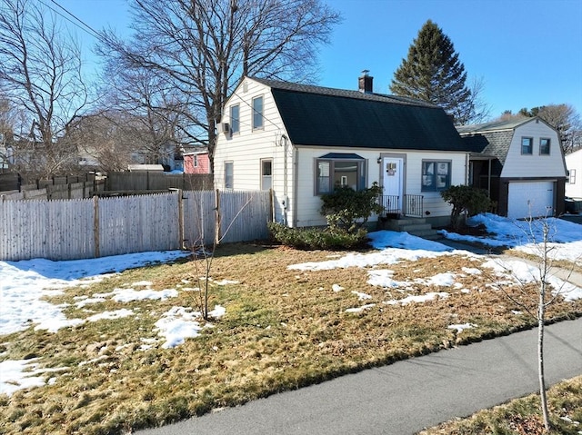 dutch colonial with roof with shingles, an attached garage, fence, and a gambrel roof