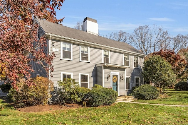 colonial-style house featuring a front lawn