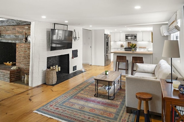 living room featuring light wood-type flooring and a fireplace