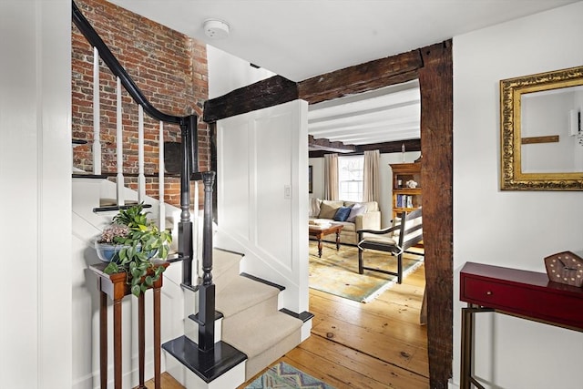 hallway featuring beamed ceiling and hardwood / wood-style floors