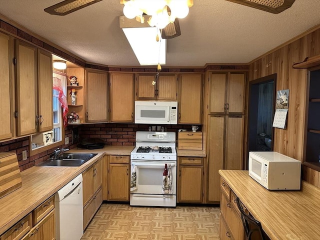 24 Arnold St, Ludlow, MA 01056 - kitchen with white appliances, light countertops, a textured ceiling, brown cabinetry, and wood walls