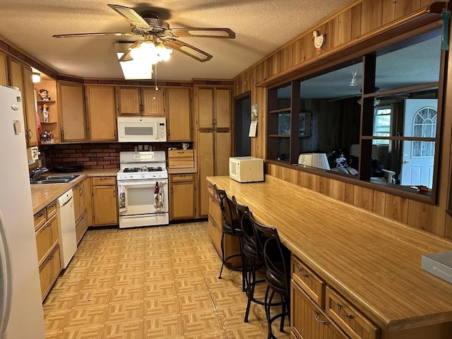 24 Arnold St, Ludlow, MA 01056 - kitchen featuring white appliances, a textured ceiling, light flooring, ceiling fan, and wooden walls