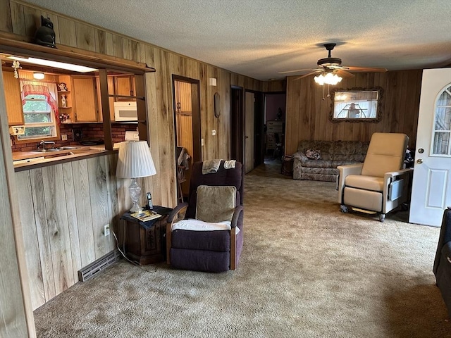 24 Arnold St, Ludlow, MA 01056 - living room featuring wood walls, carpet flooring, ceiling fan, and a textured ceiling