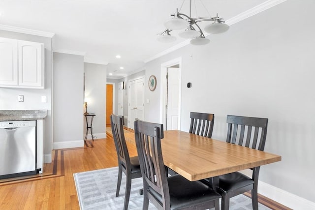 dining area with crown molding, baseboards, and light wood-type flooring