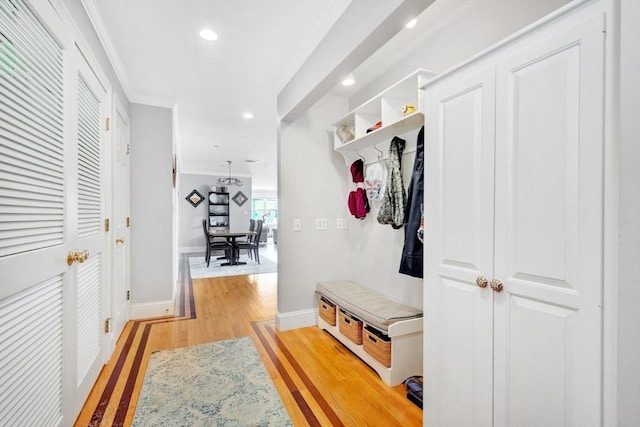 mudroom featuring baseboards, light wood-style floors, ornamental molding, and recessed lighting