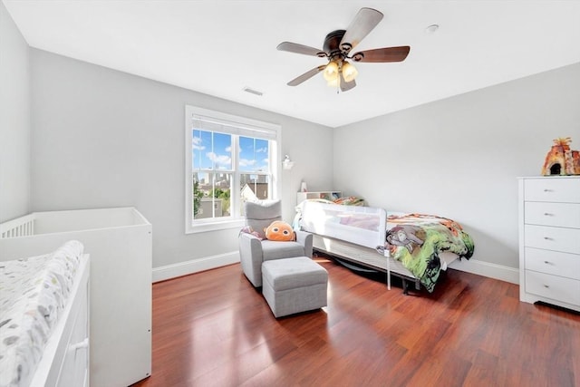 bedroom featuring wood finished floors, visible vents, baseboards, and a ceiling fan