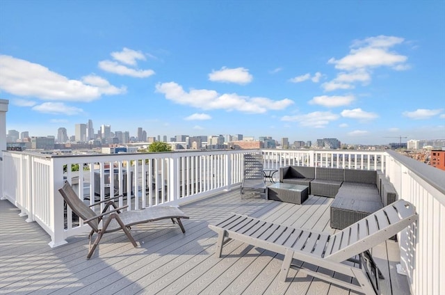 wooden terrace with a city view and an outdoor living space