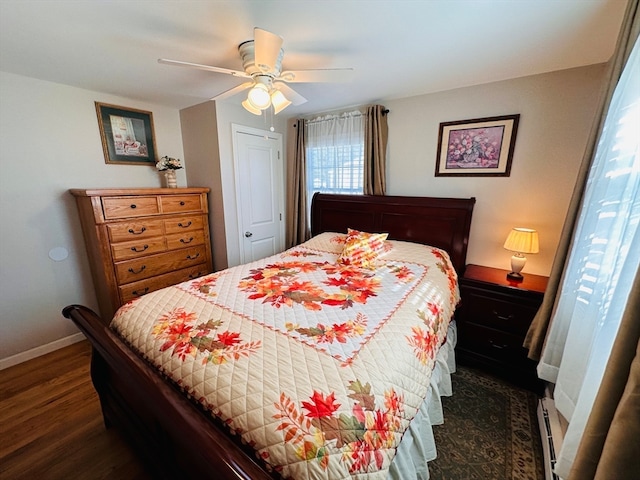 bedroom with dark wood-type flooring, ceiling fan, and a baseboard radiator