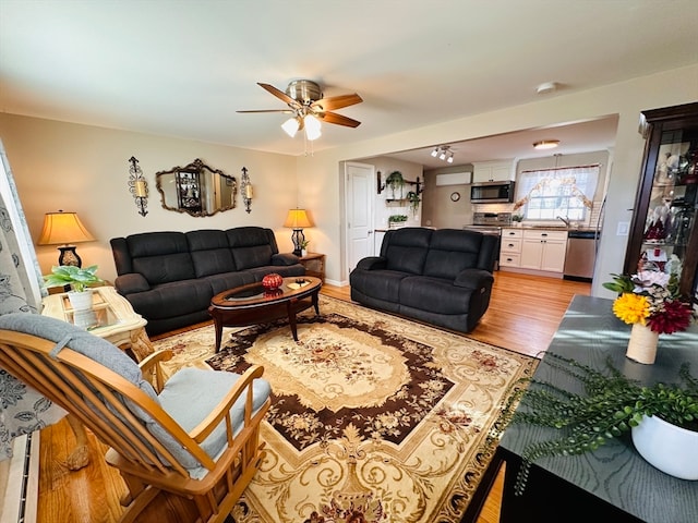 living room featuring light hardwood / wood-style flooring and ceiling fan