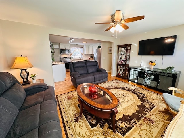 living room with light hardwood / wood-style floors and ceiling fan