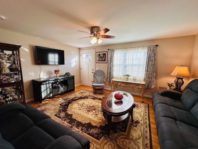 living room featuring ceiling fan, wood-type flooring, and a baseboard heating unit