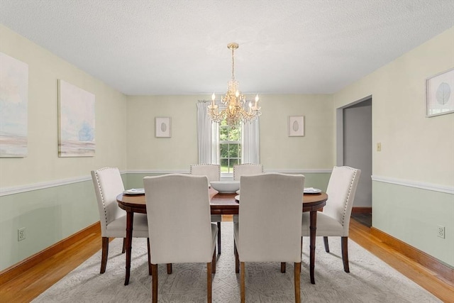 6 Lancaster Pl, Andover, MA 01810 - dining space featuring wood finished floors, a chandelier, a textured ceiling, and baseboards