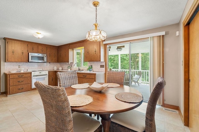 6 Lancaster Pl, Andover, MA 01810 - dining space with a textured ceiling, light tile patterned floors, a chandelier, and baseboards