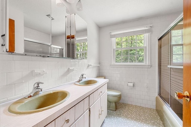 6 Lancaster Pl, Andover, MA 01810 - bathroom with tile walls, toilet, double vanity, enclosed tub / shower combo, and tile patterned flooring