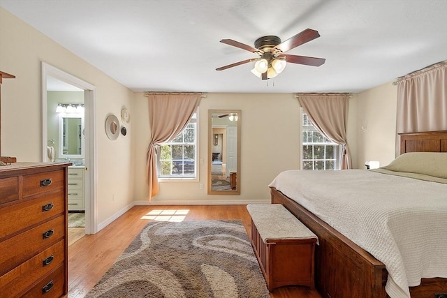 bedroom with ceiling fan, light wood-style flooring, connected bathroom, and baseboards