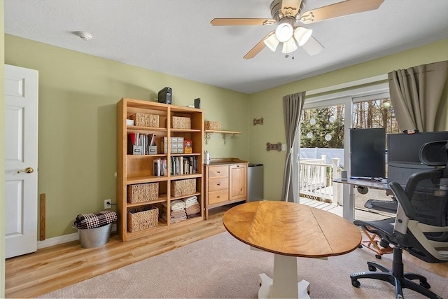 office space with a ceiling fan, light wood-style flooring, and baseboards