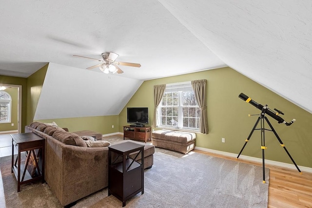 living area with ceiling fan, wood finished floors, lofted ceiling, and baseboards
