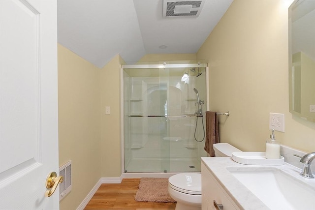 bathroom featuring wood finished floors, toilet, visible vents, and a stall shower