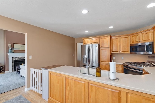 kitchen featuring light wood-style flooring, recessed lighting, appliances with stainless steel finishes, and light countertops