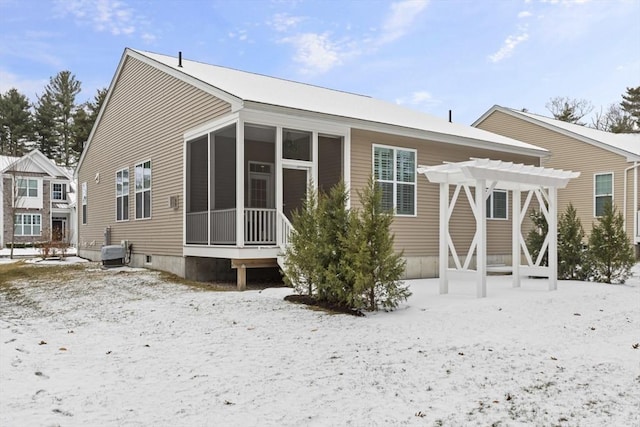 snow covered rear of property featuring a pergola and central AC unit