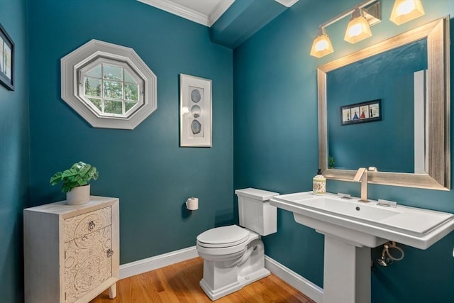 bathroom featuring baseboards, wood finished floors, toilet, and ornamental molding