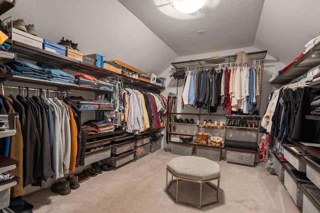 walk in closet with carpet flooring and vaulted ceiling