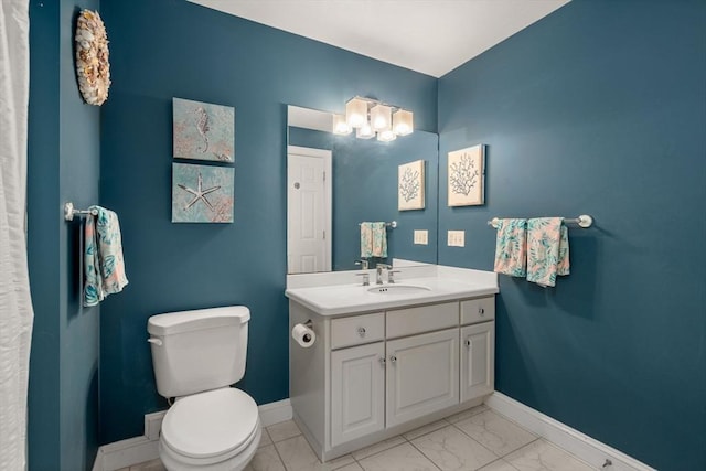bathroom featuring baseboards, marble look tiles, toilet, and vanity