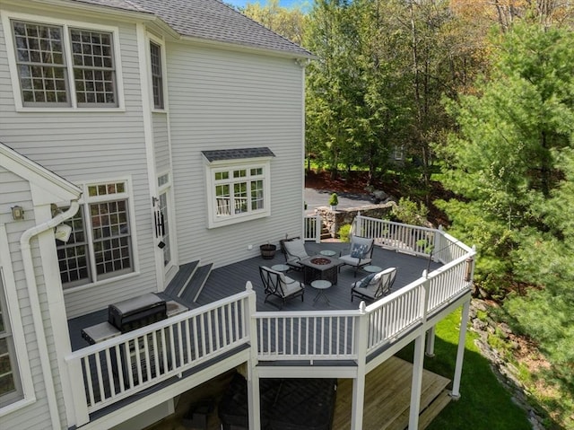 deck featuring outdoor dining area and a fire pit