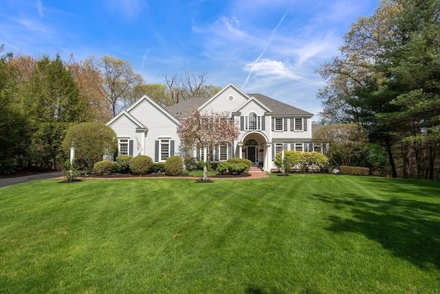 traditional-style home featuring a front lawn