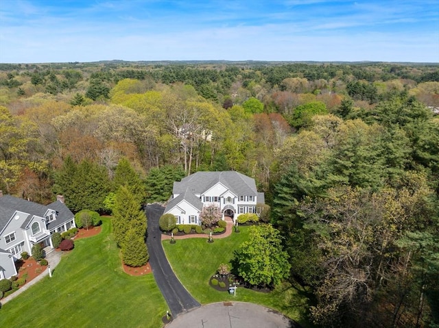 aerial view of property and surrounding area featuring a forest