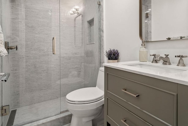 bathroom with vanity, toilet, and a shower stall