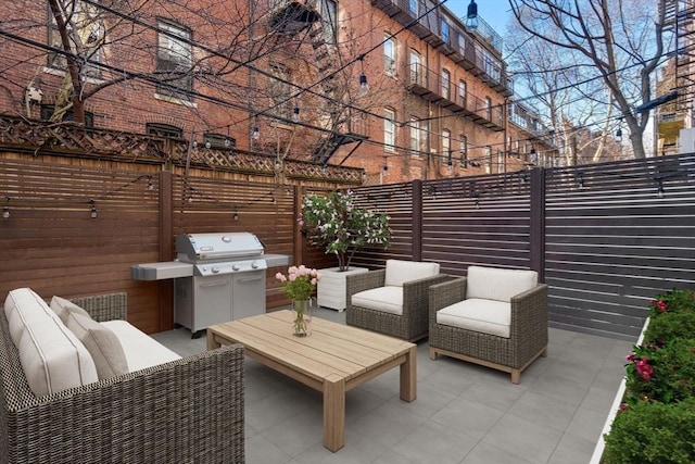 view of patio / terrace featuring area for grilling, an outdoor living space, and fence