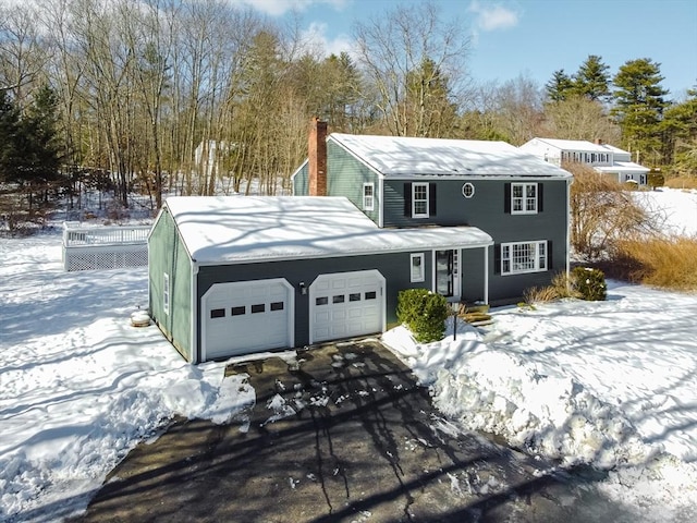 view of front of property featuring a garage, driveway, and a chimney