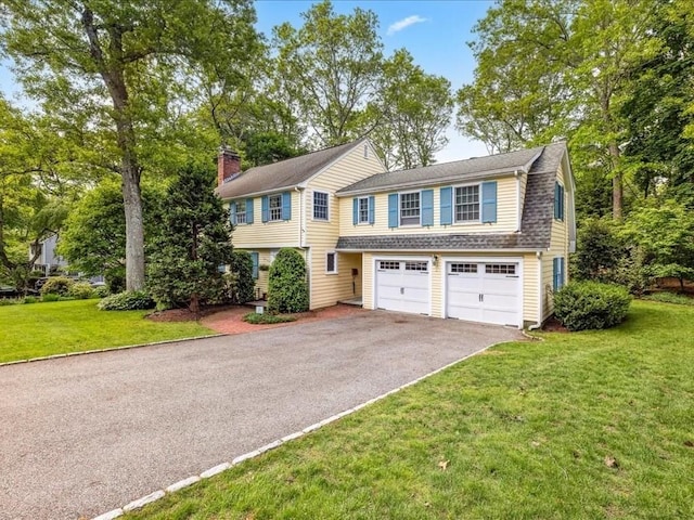234 Lowell Rd, Wellesley, MA 02481 - view of front of house featuring asphalt driveway, an attached garage, a front lawn, and a chimney