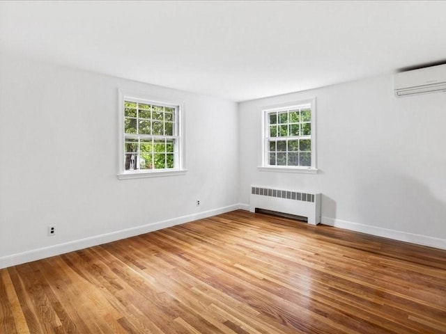 234 Lowell Rd, Wellesley, MA 02481 - unfurnished room featuring radiator, an AC wall unit, light wood-type flooring, and baseboards