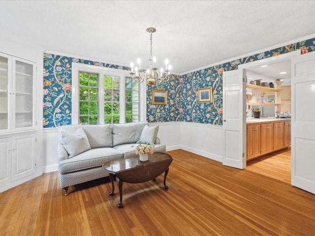 234 Lowell Rd, Wellesley, MA 02481 - living room featuring wallpapered walls, a wainscoted wall, light wood-style floors, a chandelier, and crown molding
