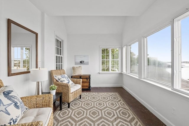 sunroom featuring vaulted ceiling, baseboards, and wood finished floors