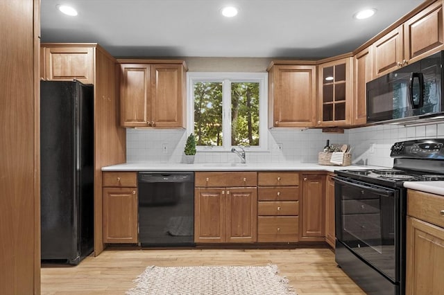 kitchen featuring black appliances, tasteful backsplash, and light countertops