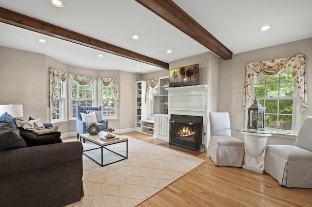 living room with a fireplace with flush hearth, baseboards, recessed lighting, beamed ceiling, and wood finished floors